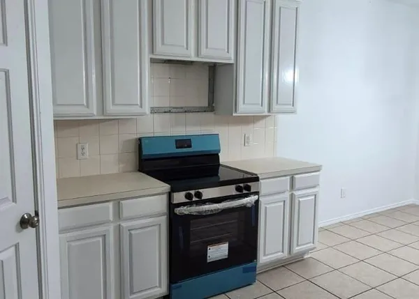 a kitchen with granite countertop white cabinets and stainless steel appliances