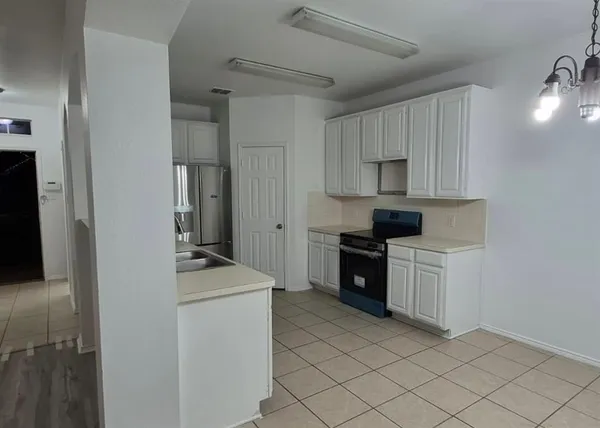 a kitchen with a stove sink and a refrigerator
