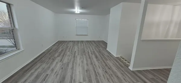 a view of a room with wooden floor