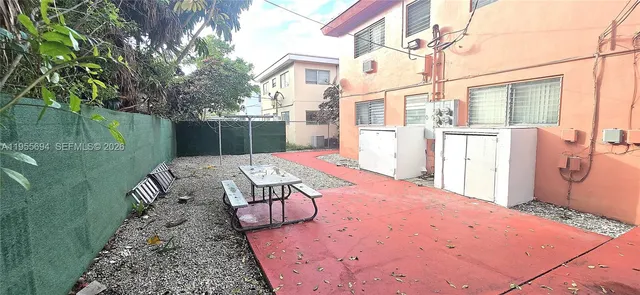 a view of backyard with a tub and wooden fence