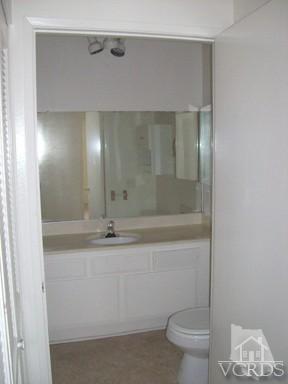 560 Spring Road, Unit 81 Moorpark, CA 93021 - Photo 14 of 14 a bathroom with a granite countertop sink a toilet a mirror and shower