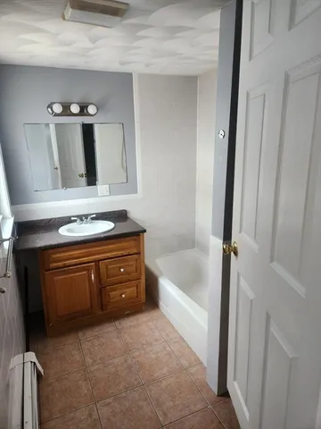 a bathroom with a tub sink and mirror