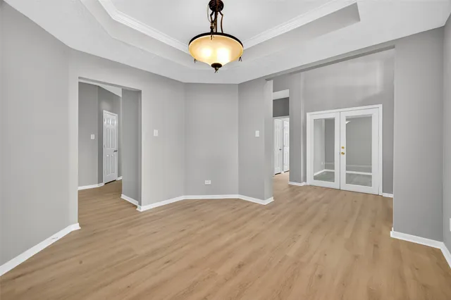 a view of an empty room with window and wooden floor