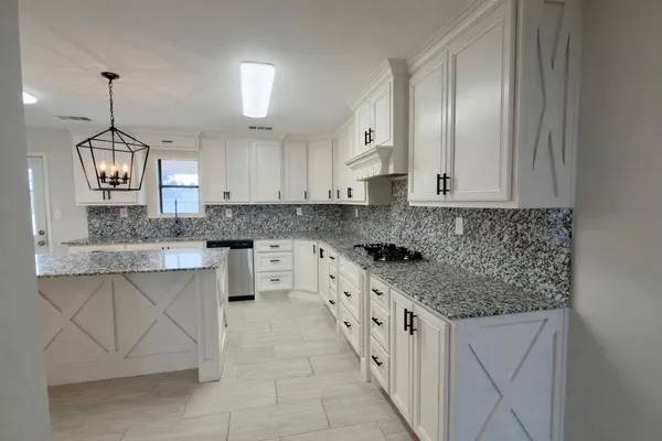 a kitchen with stainless steel appliances granite countertop a sink stove and cabinets