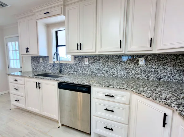 a kitchen with granite countertop white cabinets and white appliances