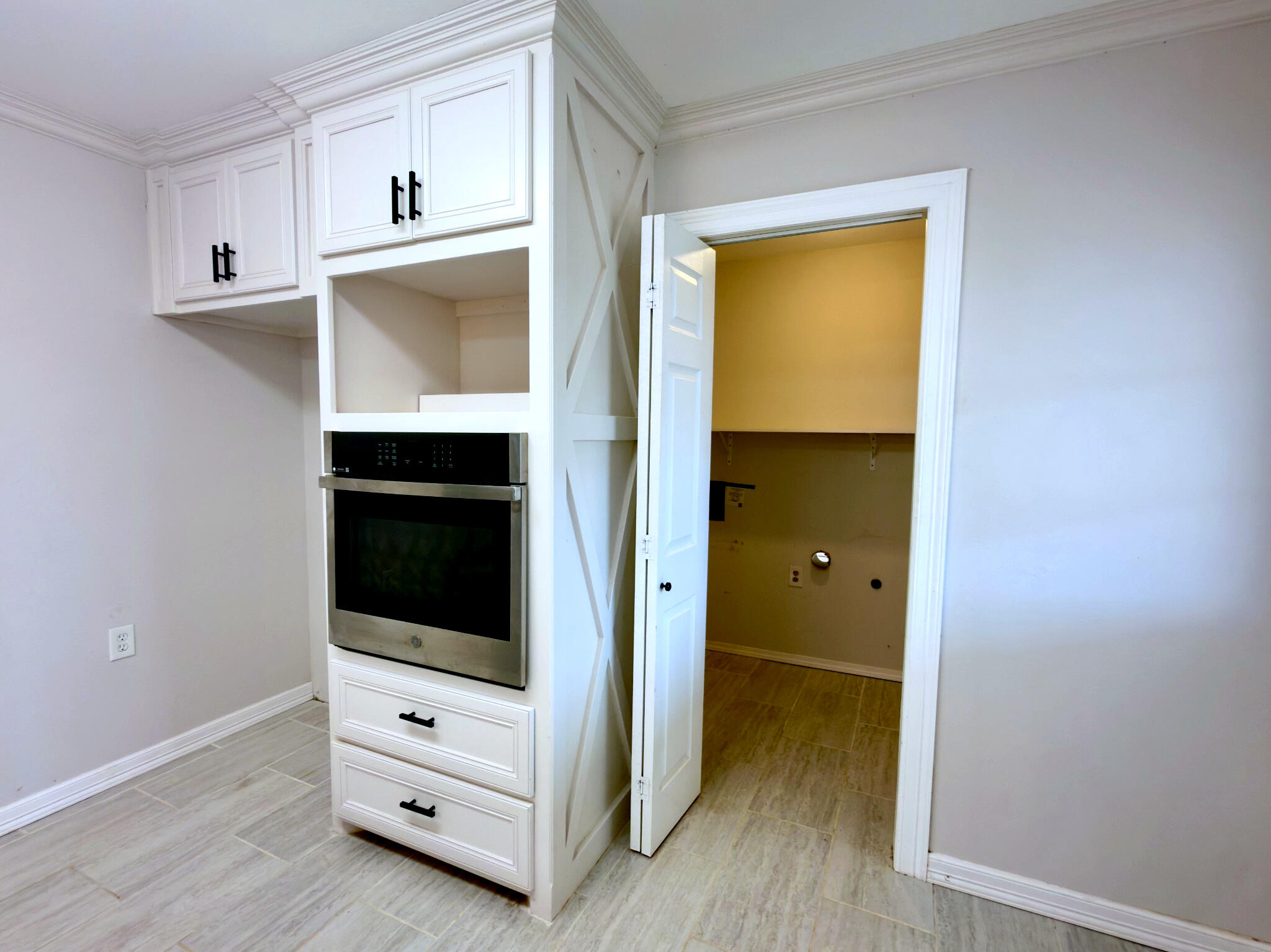 611 South Avenue H Post, TX 79356 - Photo 15 of 32 a view of an empty room with cabinet and wooden floor