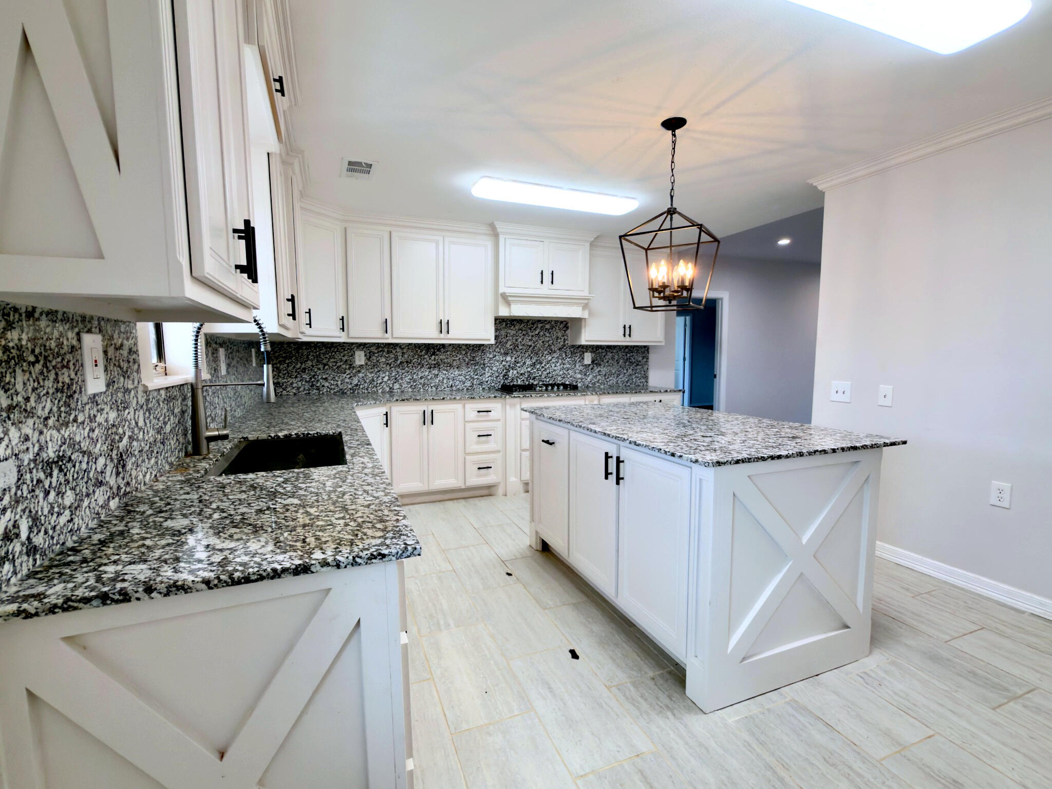 611 South Avenue H Post, TX 79356 - Photo 16 of 32 a kitchen with granite countertop a sink cabinets and wooden floor