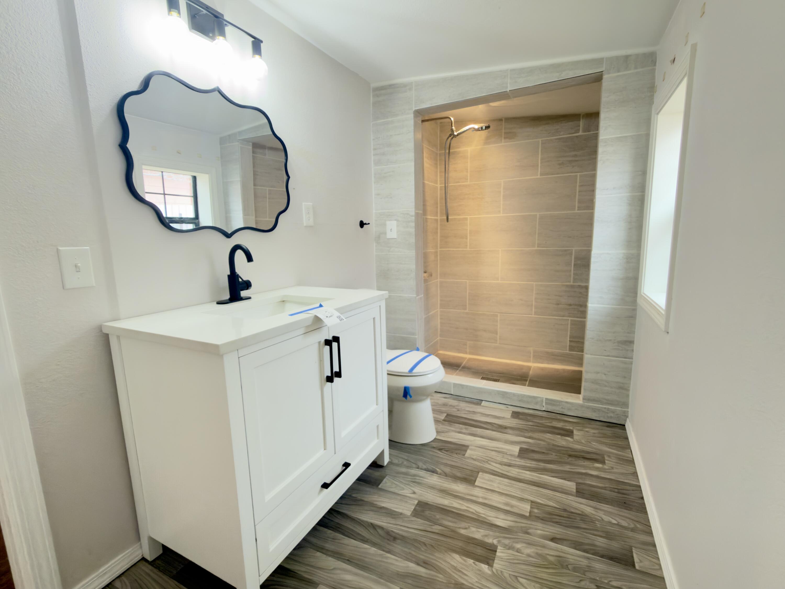 611 South Avenue H Post, TX 79356 - Photo 19 of 32 a bathroom with a sink a toilet and shower
