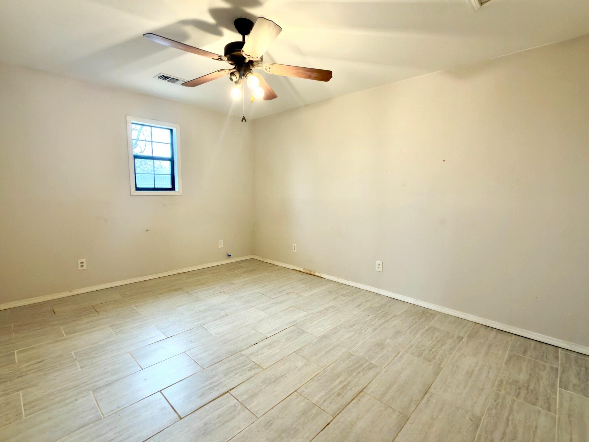 611 South Avenue H Post, TX 79356 - Photo 27 of 32 an empty room with a chandelier fan and windows