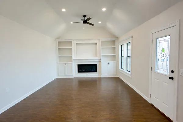 a view of an empty room with a fireplace and a window
