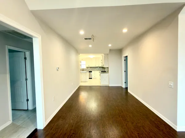 a view of a big room with wooden floor and a bathroom