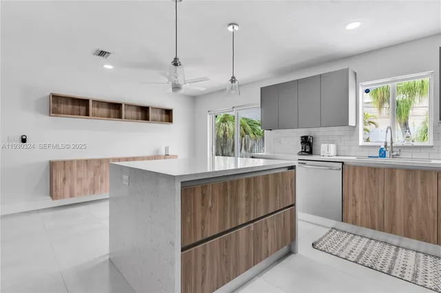 a kitchen with stainless steel appliances granite countertop a sink a microwave oven a stove and white cabinets