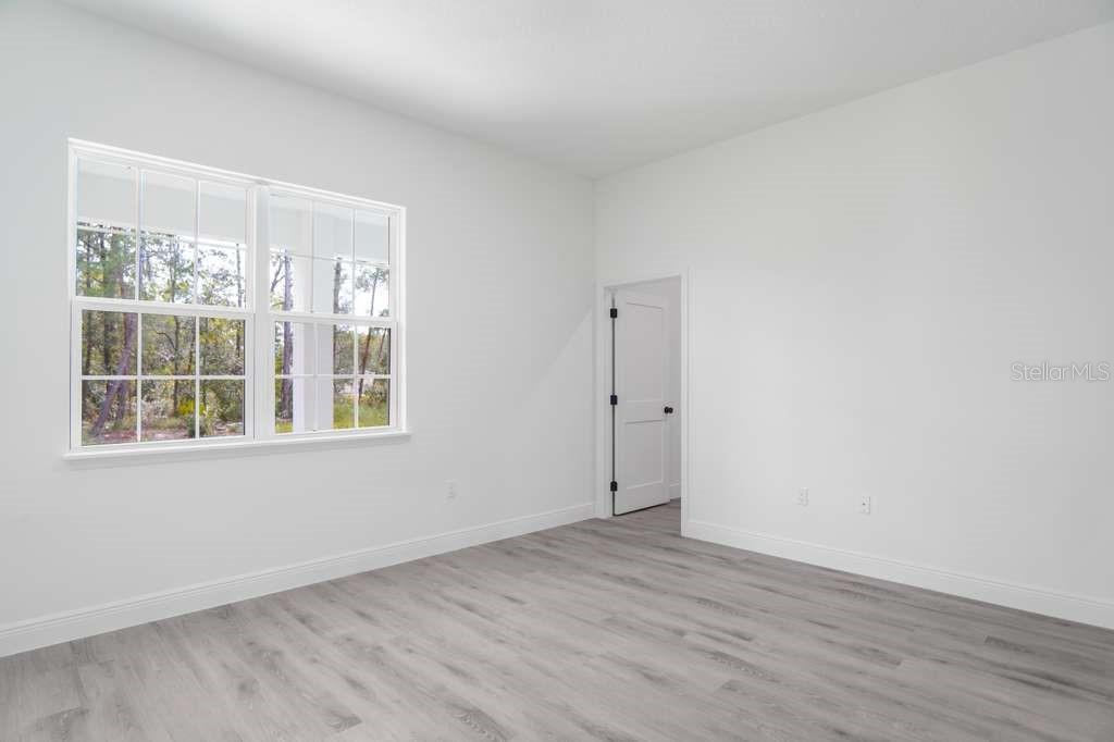 15683 Southwest 49th Avenue Road Ocala, FL 34473 - Photo 13 of 27 a view of an empty room with wooden floor and a window