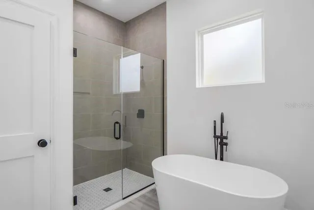 a bathroom with a toilet a sink a mirror and shower