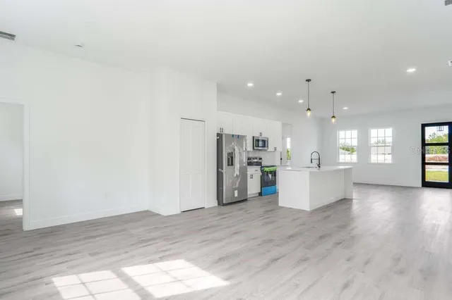 a view of a kitchen with furniture and wooden floor