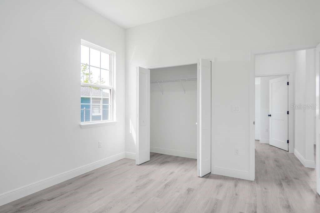 15683 Southwest 49th Avenue Road Ocala, FL 34473 - Photo 10 of 27 an empty room with wooden floor and windows