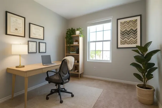 a view of a workspace with furniture and a window