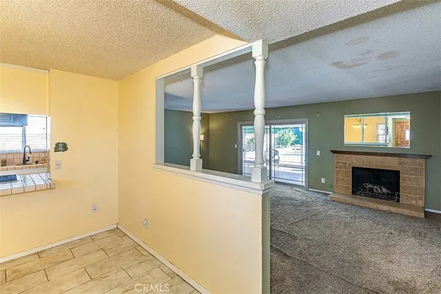 a view of an empty room with window and fire place