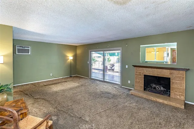 a view of an empty room with a fireplace and a window