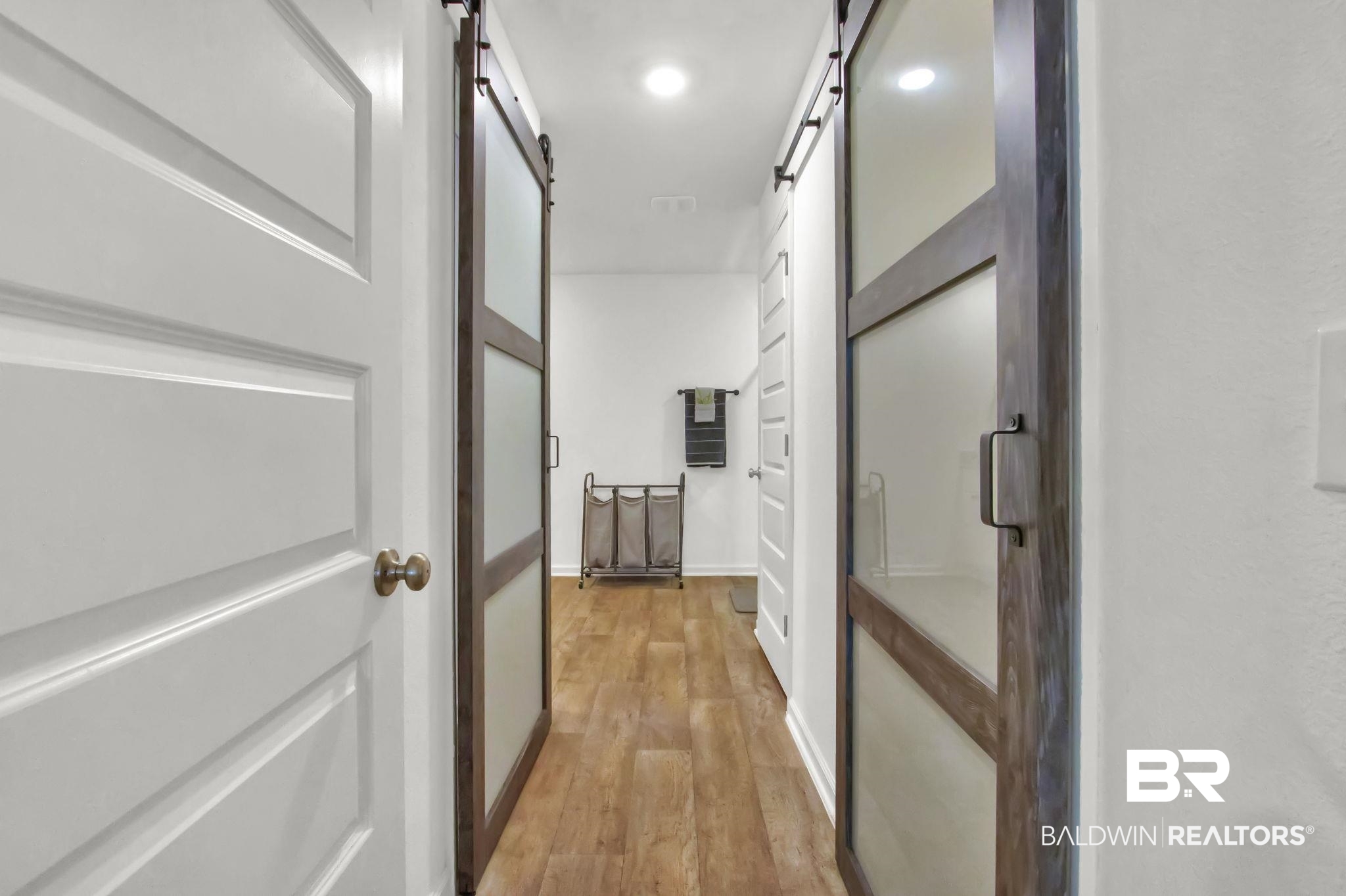 23810 Unbridled Loop Daphne, AL 36526 - Photo 18 of 50 Corridor into primary bathroom featuring barn doors that enter into dual walk-in closets