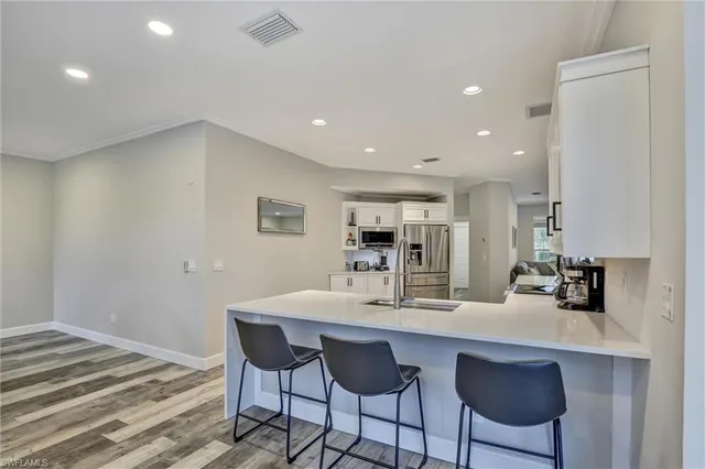 a kitchen with a dining table chairs and wooden floor
