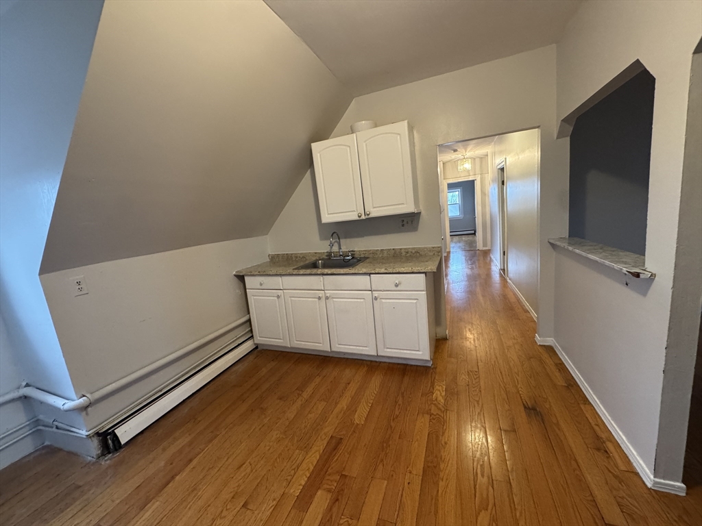 25 Amherst Street, Unit 4 Boston, MA 02131 - Photo 4 of 9 a kitchen with wooden floors and white walls
