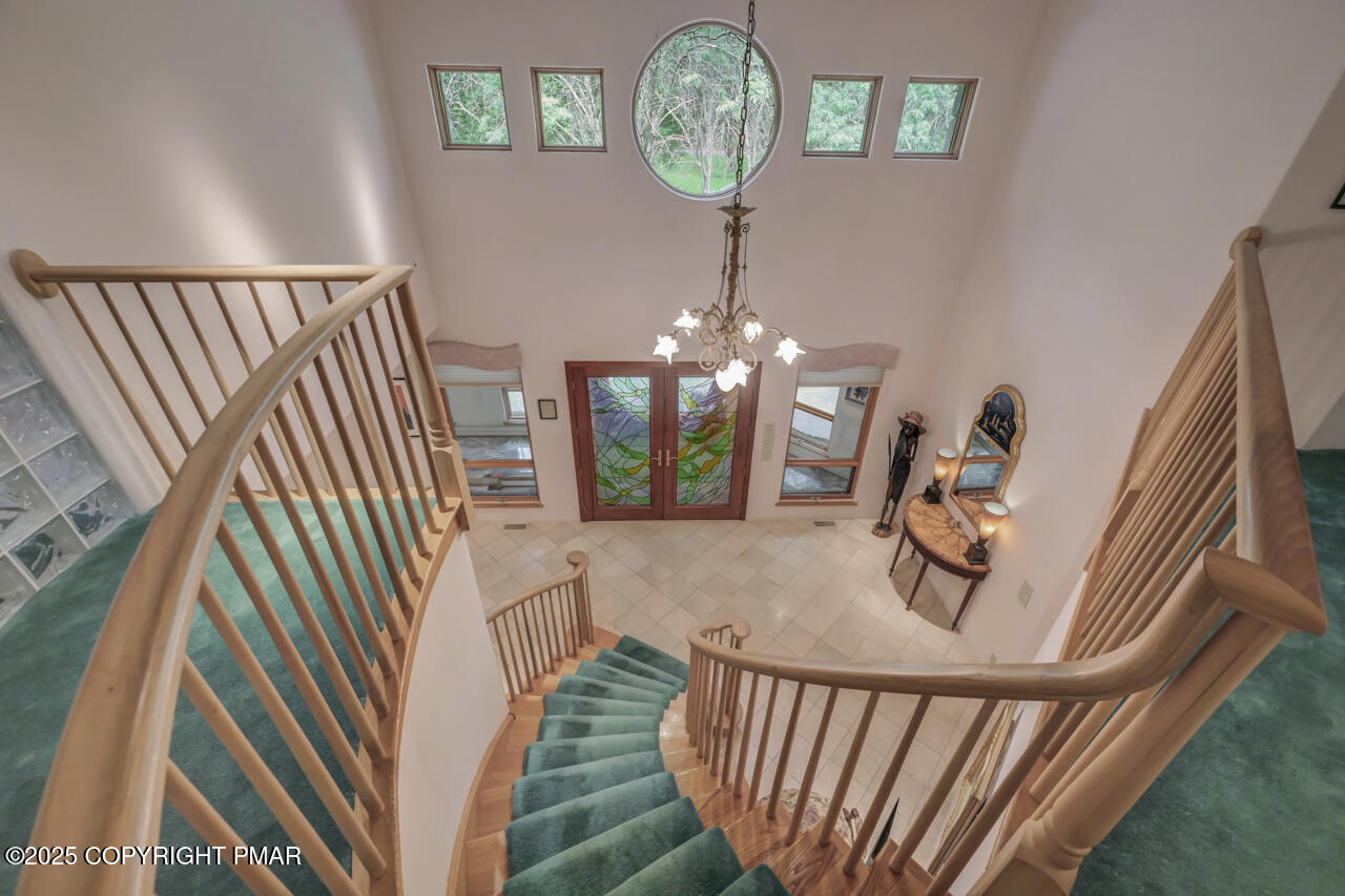 6696 Cherry Valley Road Stroudsburg, PA 18360 - Photo 12 of 97 a view of a hallway with wooden floor and a chandelier