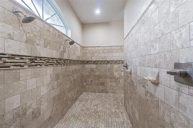 a spacious bathroom with a granite countertop sink a large mirror and a shower