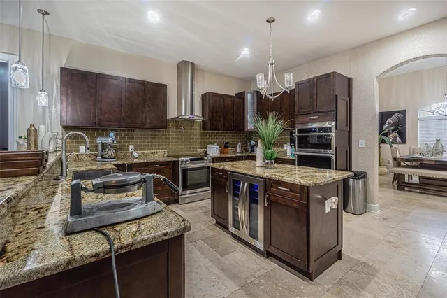 a kitchen with stainless steel appliances granite countertop a stove top oven a sink dishwasher a refrigerator and a oven