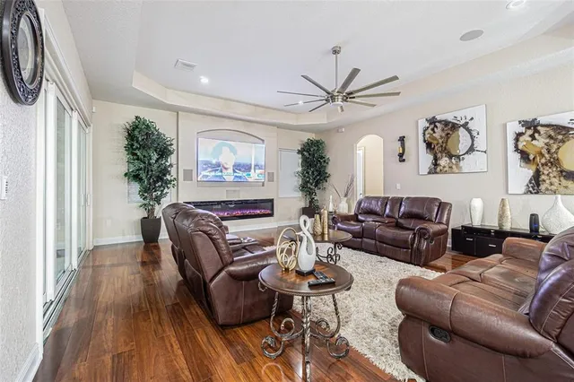 a living room with furniture a large window and wooden floor