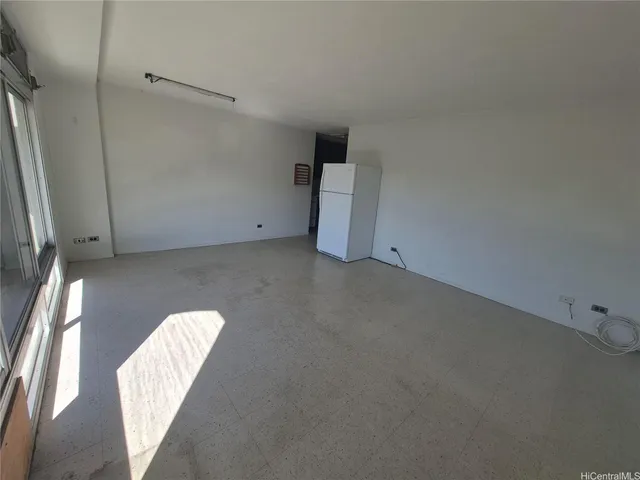 a view of empty room with wooden floor and fireplace