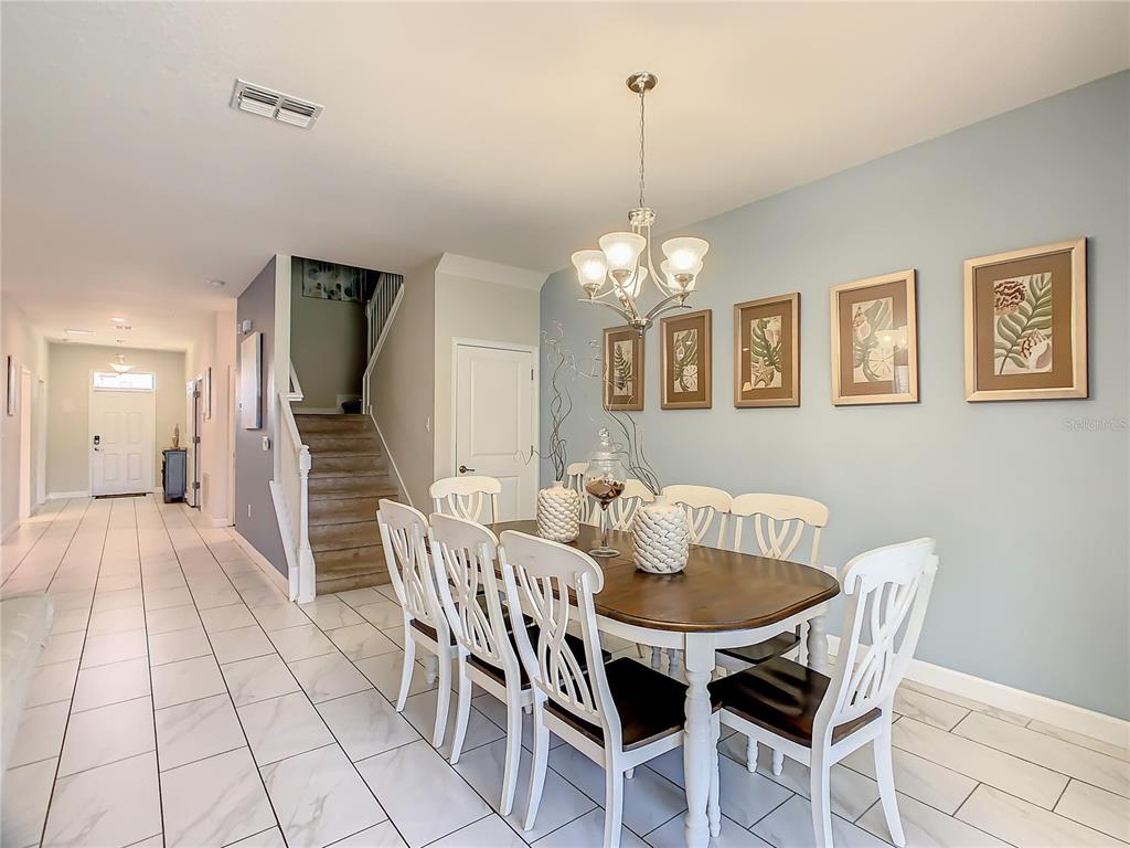 1305 Divot Way Davenport, FL 33896 - Photo 15 of 19 a view of a dining room with furniture and chandelier