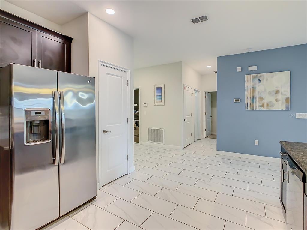 1305 Divot Way Davenport, FL 33896 - Photo 18 of 19 a view of a refrigerator in kitchen and an empty room
