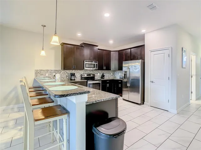 a kitchen with kitchen island a sink stove and refrigerator