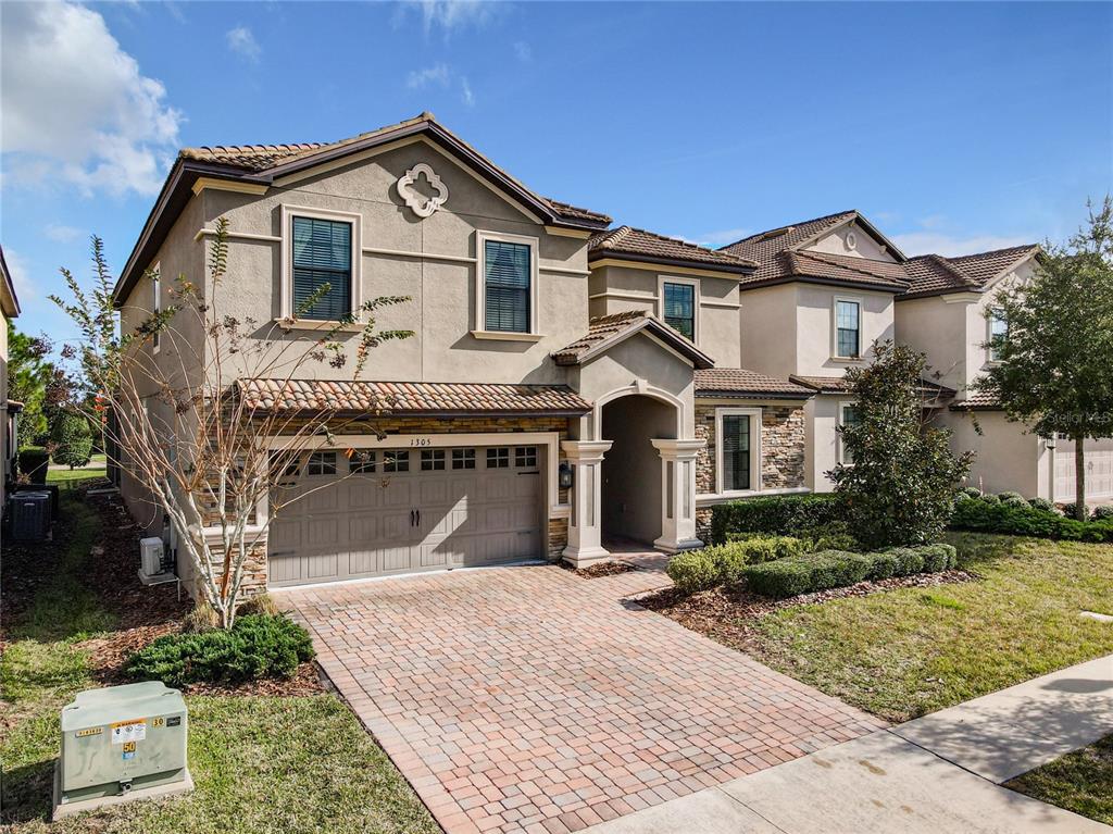 1305 Divot Way Davenport, FL 33896 - Photo 2 of 19 a front view of a house with a yard and garage