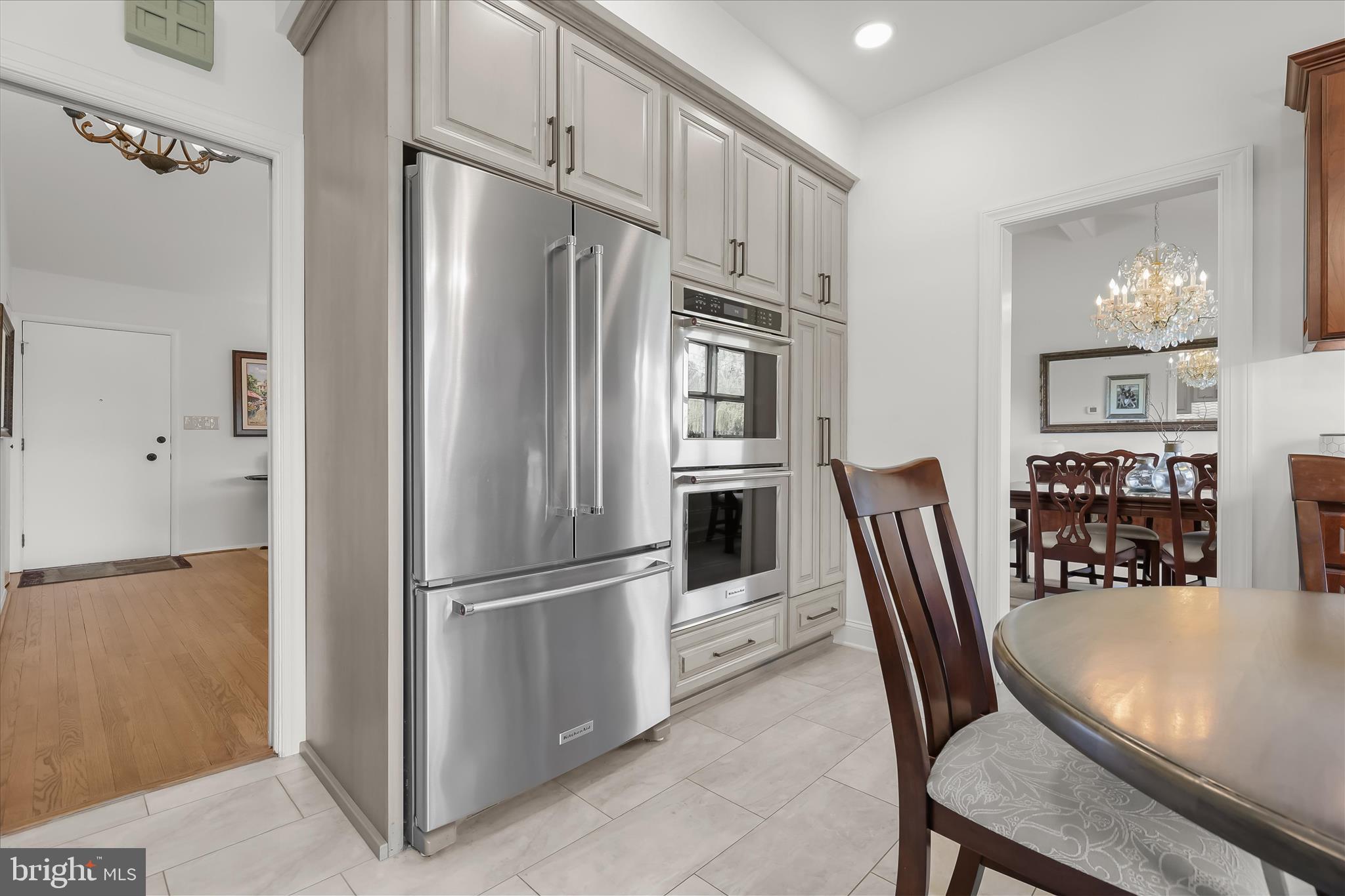 3416 Manor Hill Road Pikesville, MD 21208 - Photo 23 of 68 a kitchen with stainless steel appliances a refrigerator a stove a dining table and chairs
