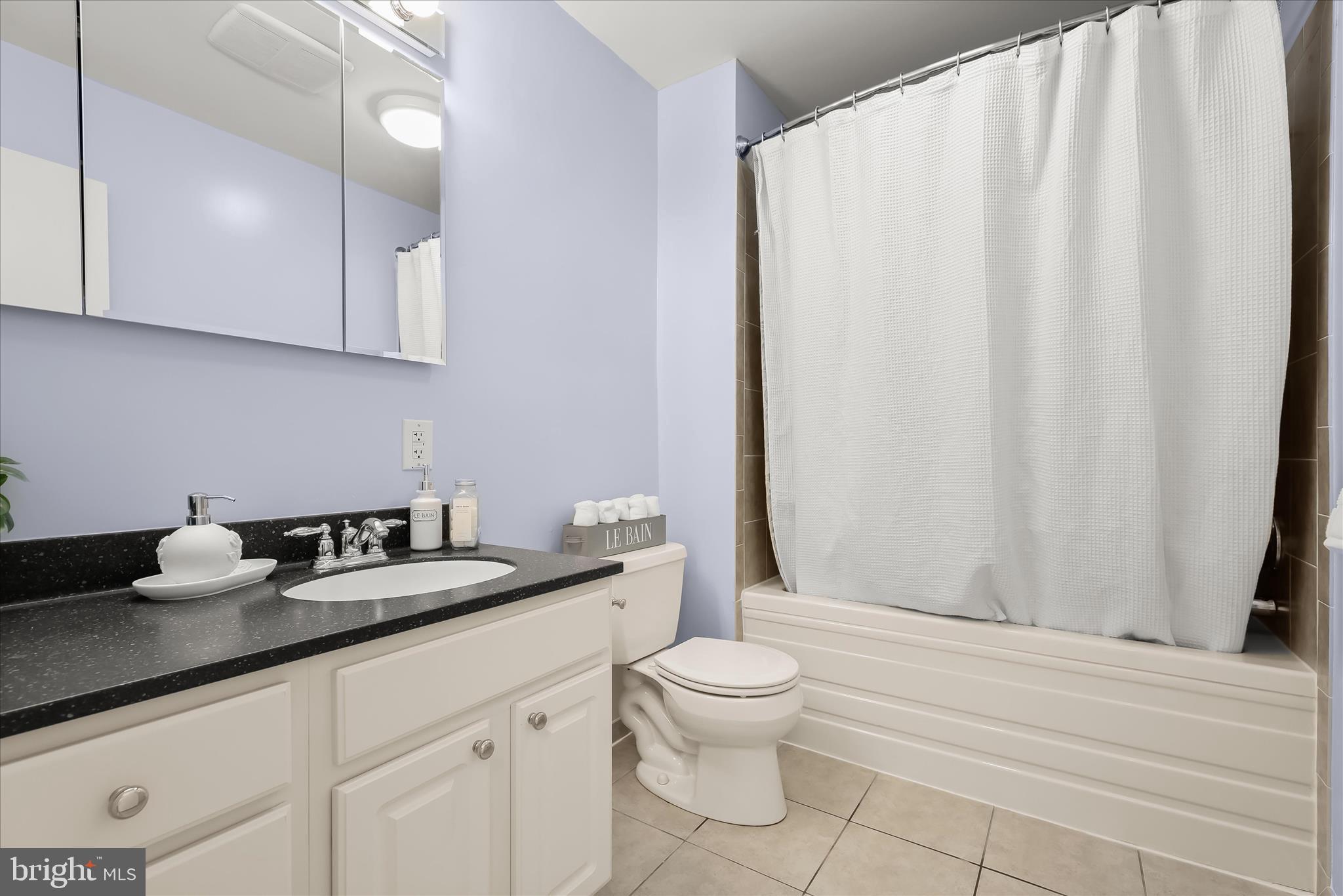 3416 Manor Hill Road Pikesville, MD 21208 - Photo 35 of 68 a bathroom with a granite countertop sink a toilet and a shower curtain