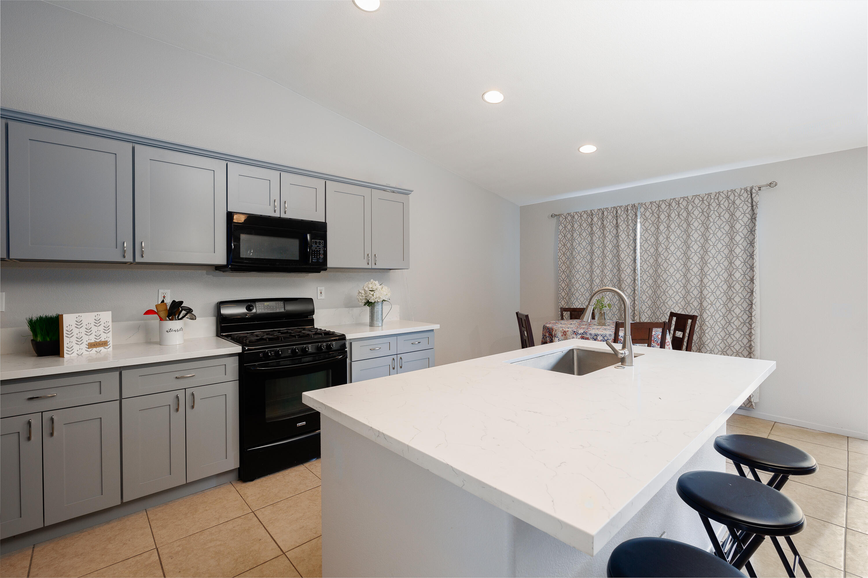 a kitchen with stainless steel appliances a stove a sink a microwave a refrigerator and cabinets