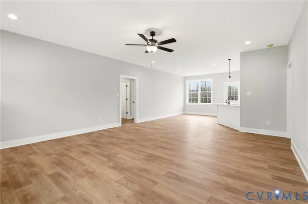 a view of an empty room with window and wooden floor