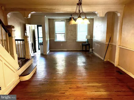 a view of a hallway with wooden floor and windows