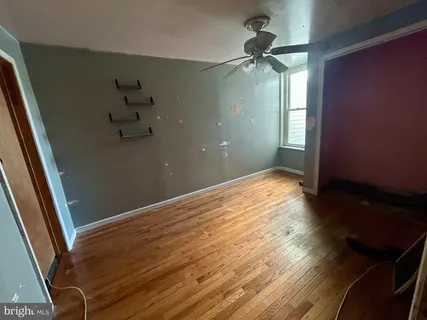a view of a room with wooden floor and fan