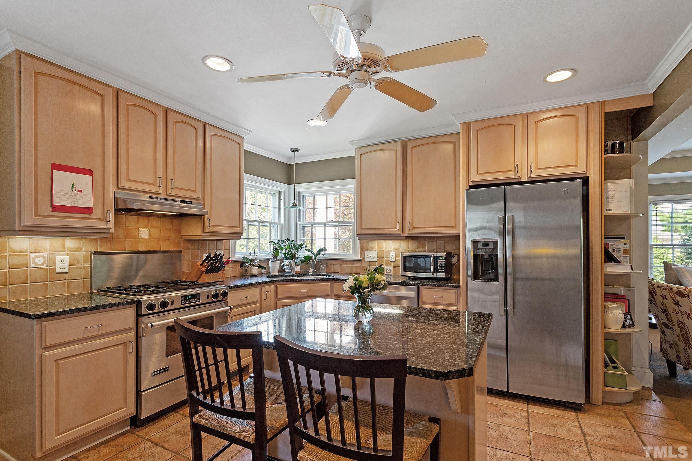 121 Lake Boone Trail Raleigh, NC 27608 - Photo 18 of 29 a kitchen with stainless steel appliances granite countertop a refrigerator a sink a stove a dining table and chairs
