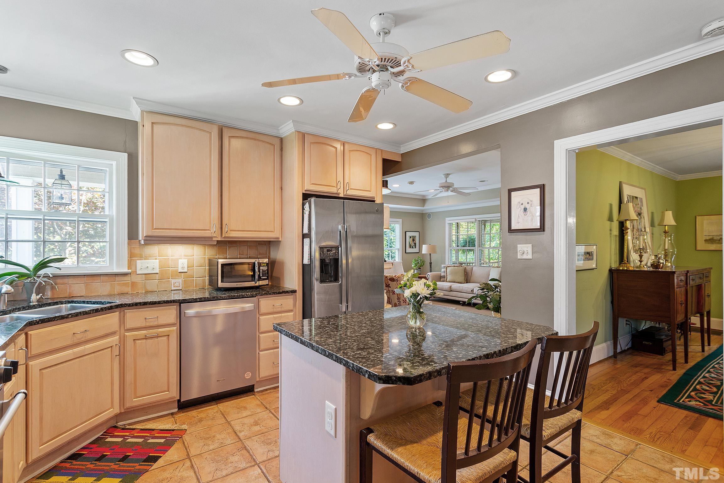 121 Lake Boone Trail Raleigh, NC 27608 - Photo 20 of 29 a kitchen with stainless steel appliances granite countertop a table chairs sink refrigerator and cabinets