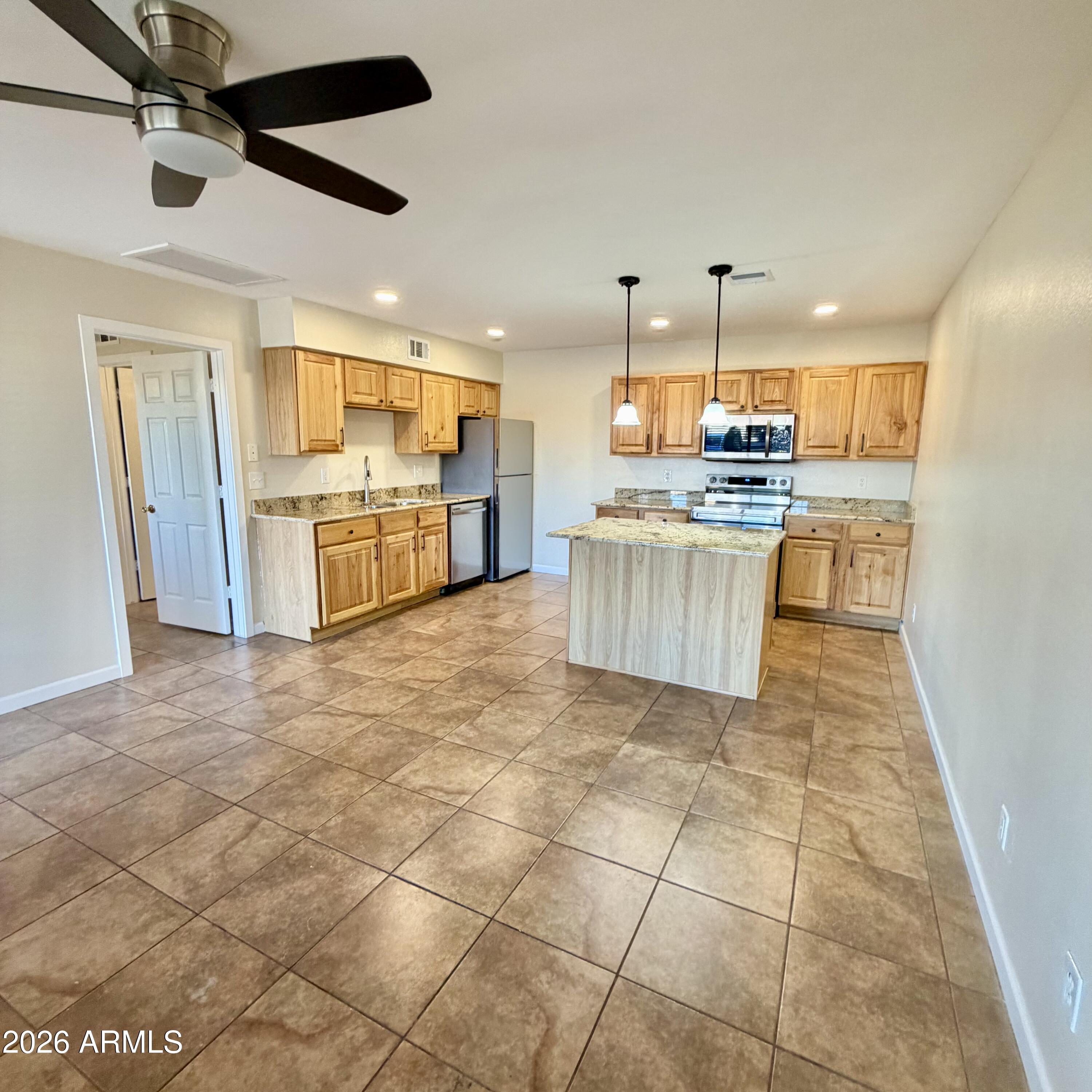 a kitchen with stainless steel appliances granite countertop a sink and a refrigerator