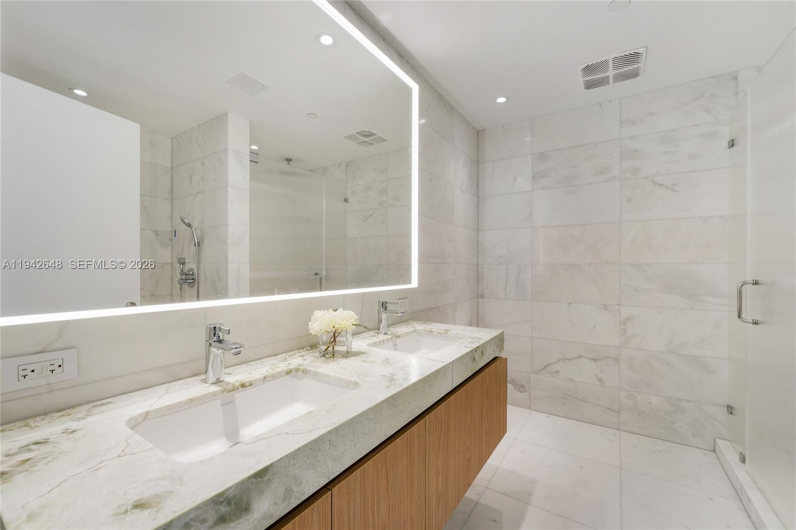 500 Alton Road, Unit 1506 Miami Beach, FL 33139 - Photo 12 of 21 a bathroom with a granite countertop double vanity sink a mirror and a bathtub