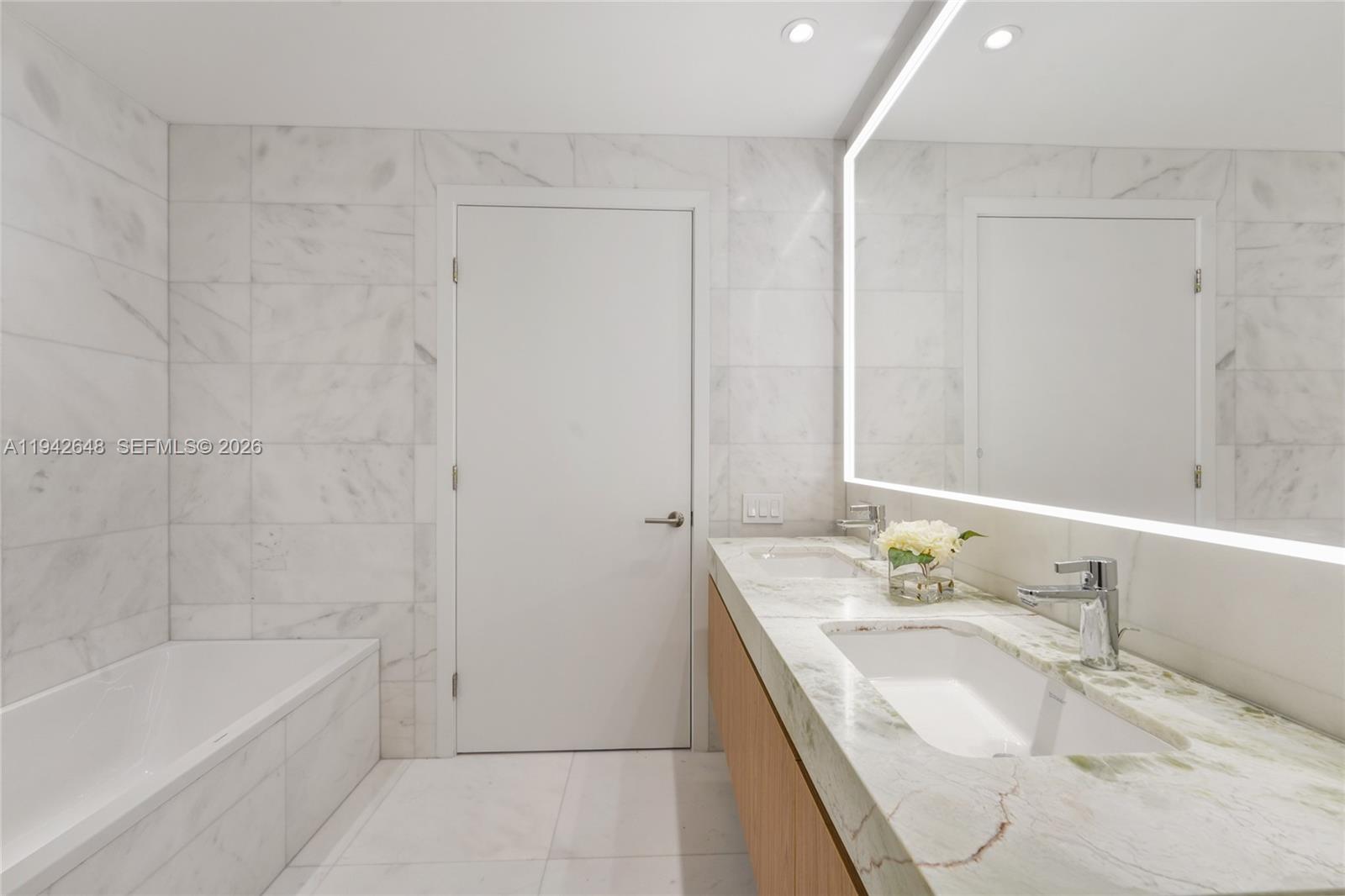 500 Alton Road, Unit 1506 Miami Beach, FL 33139 - Photo 13 of 21 a bathroom with a granite countertop sink and a bathtub