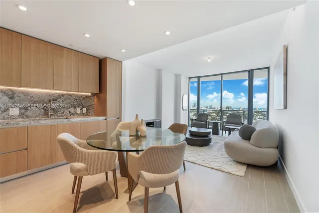 a living room with furniture and floor to ceiling windows