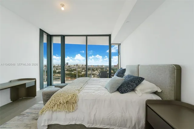 a large bed sitting in a bedroom next to a large window