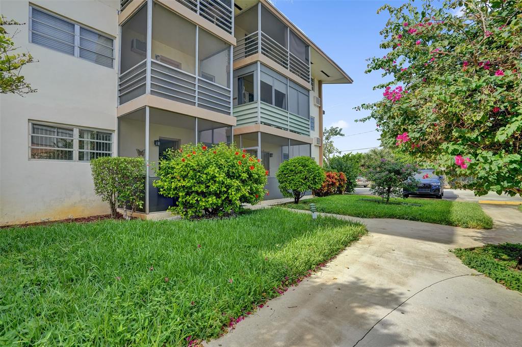 17001 Northeast 13th Avenue, Unit 104 Miami, FL 33162 - Photo 29 of 41 a front view of a house with a yard and plants