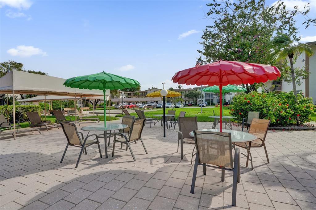 17001 Northeast 13th Avenue, Unit 104 Miami, FL 33162 - Photo 33 of 41 a patio with a patio table and chairs
